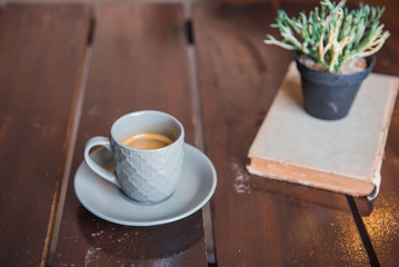 Cup coffee on White wooden table and old book and pot .