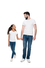 Happy multiethnic father and daughter holding hands and smiling each other isolated on white