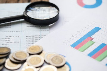 coins on bank account passbook and business chart