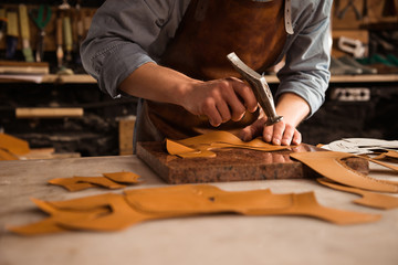 Close up of a shoemaker man working with leather - Powered by Adobe