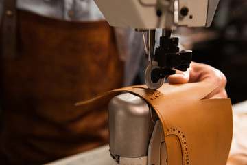 Close up of a shoemaker using sewing machine