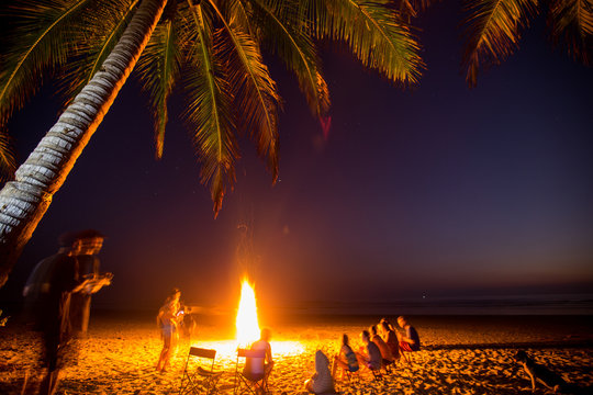 Surfers gather around a campfire on the beach in Santa Teresa, Costa Rica