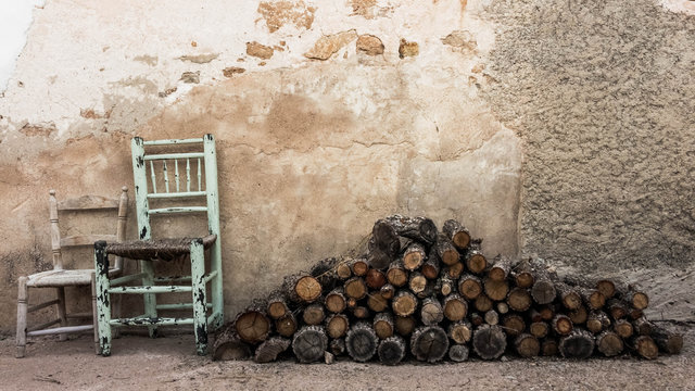 Leña apilada y sillas viejas