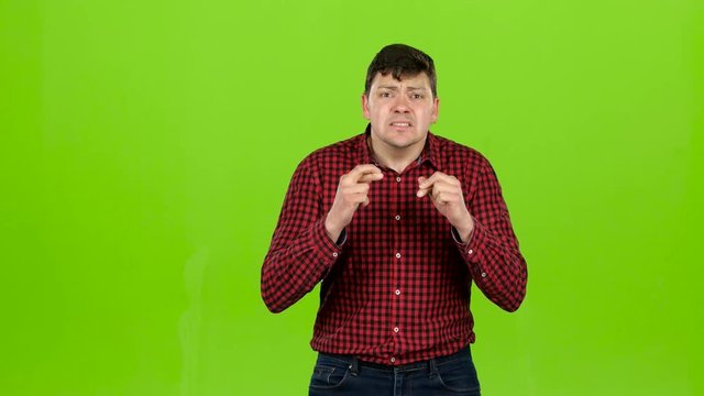 Man is a fan of the team, crossing his fingers in his arms. Green screen