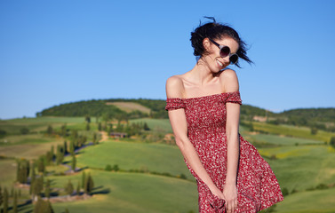 View of a girl in red dress in Tuscany hills, Italy