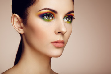 Portrait of beautiful young woman with rainbow make-up. Girl summer. Long eyelashes, vivid colorful eyeshadows. Multicolored