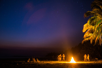 Surfers gather around a campfire on the beach in Santa Teresa, Costa Rica