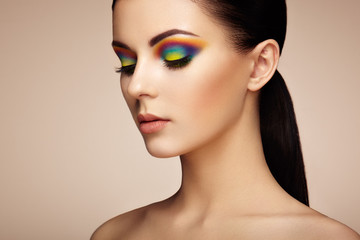 Portrait of beautiful young woman with rainbow make-up. Girl summer. Long eyelashes, vivid colorful...