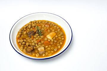 Stew of  chickpeas chorizo and pork.Isolated