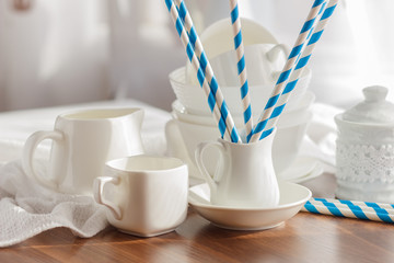 Set of white empty tableware with striped tubules