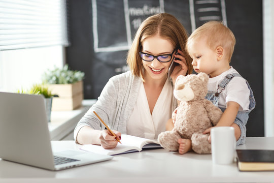 Businesswoman mother  woman with toddler working at computer
