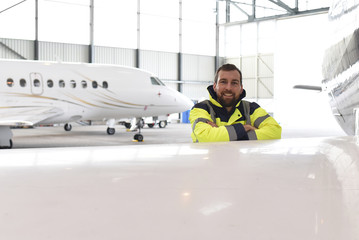 Techniker im Hangar einer Flugzeugwerft - Sicherheit im Luftverkehr // Engineer in the hangar of an airframe - safety in air traffic - obrazy, fototapety, plakaty