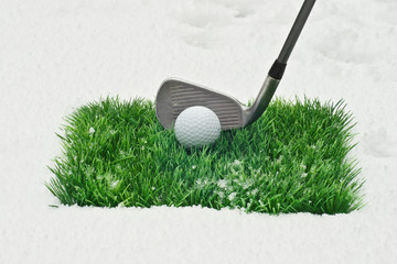 Golf im Winter-Golfball und Eisen auf Kunstrasen im Schnee