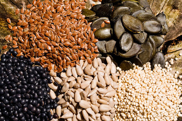 Pumpkin seeds, sunflower, chickpeas, quinoa and flax seeds on a wooden background.