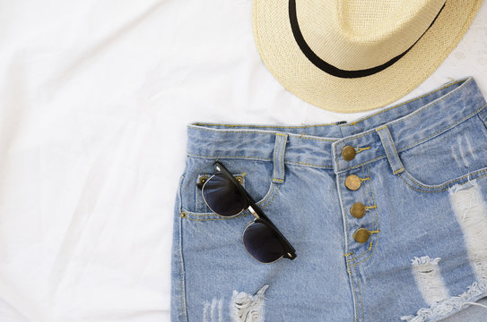 Summer clothes on white background. Sunglasses, shorts and hat
