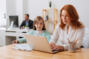 Charming engaged child helping her mom at work