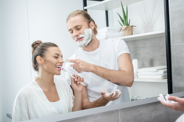 portrait of cheerful couple having fun while doing morning routine