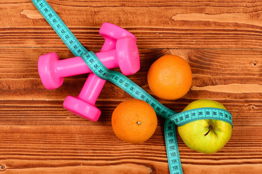 meter tape, dumbbells weight and apple, orange for diet concept