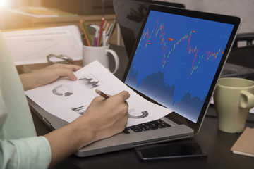 business working on laptop with Finance Trading Stock Graph Chart homepage on computer screen....