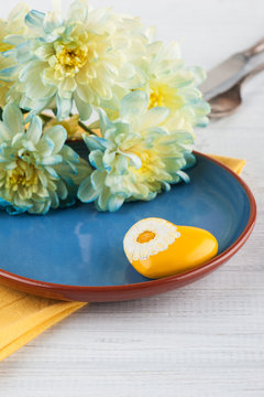 Chrysanthemum flowers on a plate on a wooden table