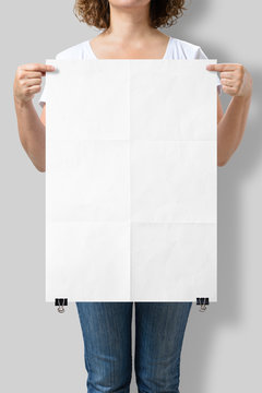 Woman Holding A Blank A2 Poster Mockup Isolated On A Gray Background. 