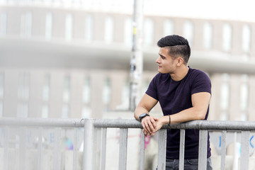 Young man leaning on railing looking away
