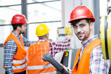 Portrait of confident man wearing hard hat in factory