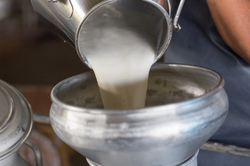 Worker pouring milk into a container for transform.