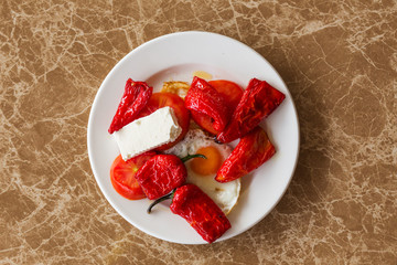 Breakfast. Baked peppers, fried eggs, cheese on a plate.