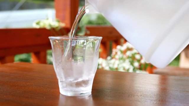 Water pouring in glass of water 