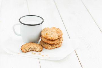 Cookies and a cup of milk on a light wooden table