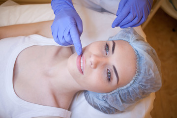 Obraz na płótnie Canvas Cosmetology doctor makes woman treatments facial massage