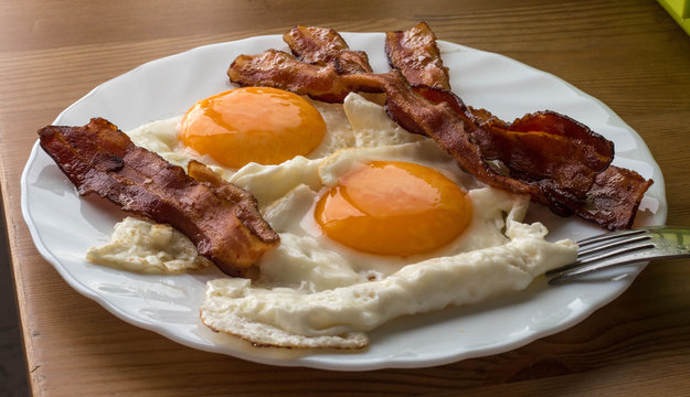 Bacon and eggs. Breakfast. Country style fried eggs with pork ham