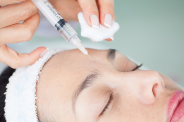 Doctor applying a facial treatment using a syringe