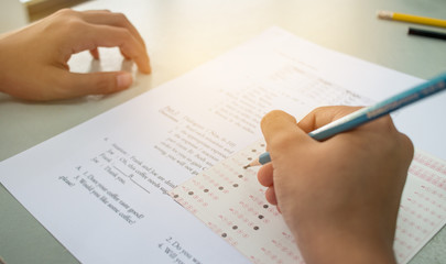 Asian student testing english exam or exercise on exams answer sheets with pencil in class room at school, education concept - obrazy, fototapety, plakaty
