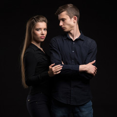Young serious couple portrait of a confident businessman on a black background. Ideal for banners, registration forms, presentation, landings, presenting concept.