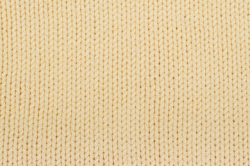 Sweater or scarf fabric texture large knitting. Knitted jersey background with a relief pattern. Wool hand- machine, handmade, yellow.