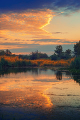 Beautiful sky reflection in river during summer sunset