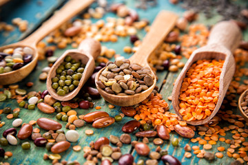 Raw legume on old rustic wooden table. - obrazy, fototapety, plakaty