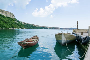 Small Fishing Boats In Fishing Bay Near Cliffs