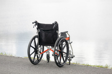 Fototapeta na wymiar Empty wheelchair on lake
