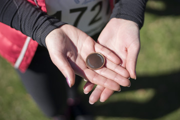 Young woman is holding medal in the hands