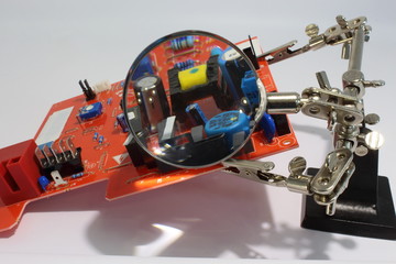 Electronic board with soldering iron, magnifying glass and 