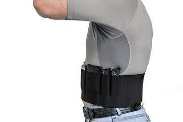 Torso of a man dressed in civilian clothes, underneath the shirt there is a set for concealed carry weapons. Face hidden