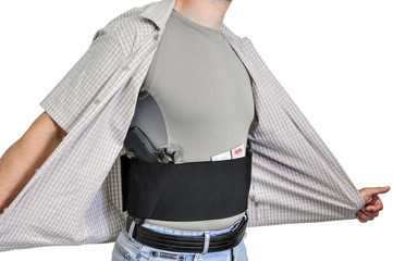 Torso of a man dressed in civilian clothes, underneath the shirt there is a set for concealed carry...