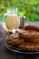 Delicious homemade cookies and jug of milk in sunshine on table. Home food