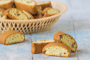 Rusks. Homemade rusks with raisins in a small plastic basket on a blue wooden background.