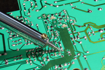 Electronic board with soldering iron, magnifying glass and "third hand".