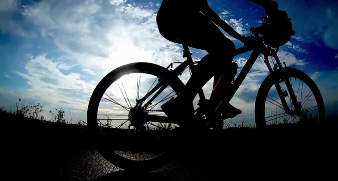 girl rides a bike against the sun