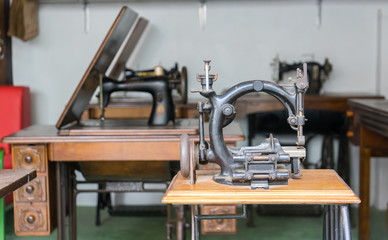 Old and Dusty Black Round Sewing Machine in Vintage Style on Wooden Table. No in used and now used for Decoration.